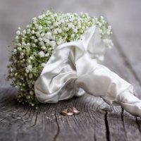 15934857 - wedding  bouquet and rings on a dark wooden background.